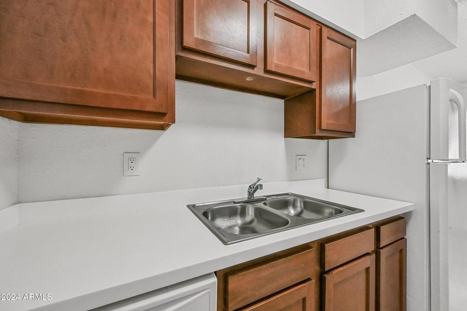 1518 West Colter Street, Unit 10 Phoenix, AZ 85015 - Photo 7 of 14 a kitchen with a sink cabinets and a refrigerator