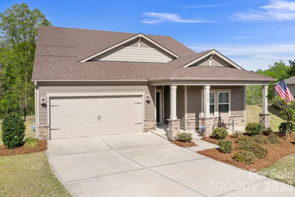 a sign that is sitting on a wooden bench in a yard
