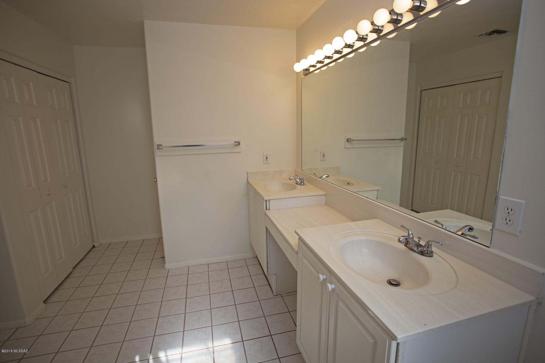 5851 South Avra Road Tucson, AZ 85735 - Photo 19 of 46 a bathroom with a sink a mirror and a shower