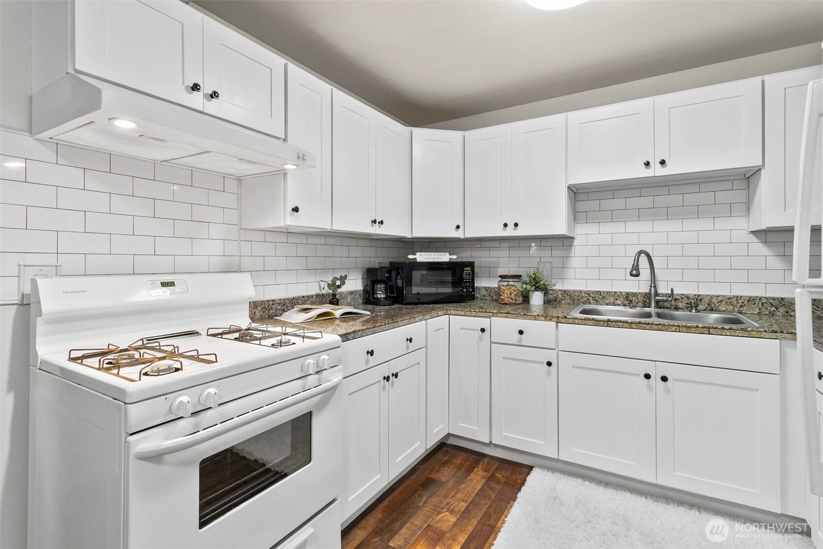 26604 191st Place Southeast Covington, WA 98042 - Photo 12 of 34 a kitchen with granite countertop white cabinets stove top oven and sink
