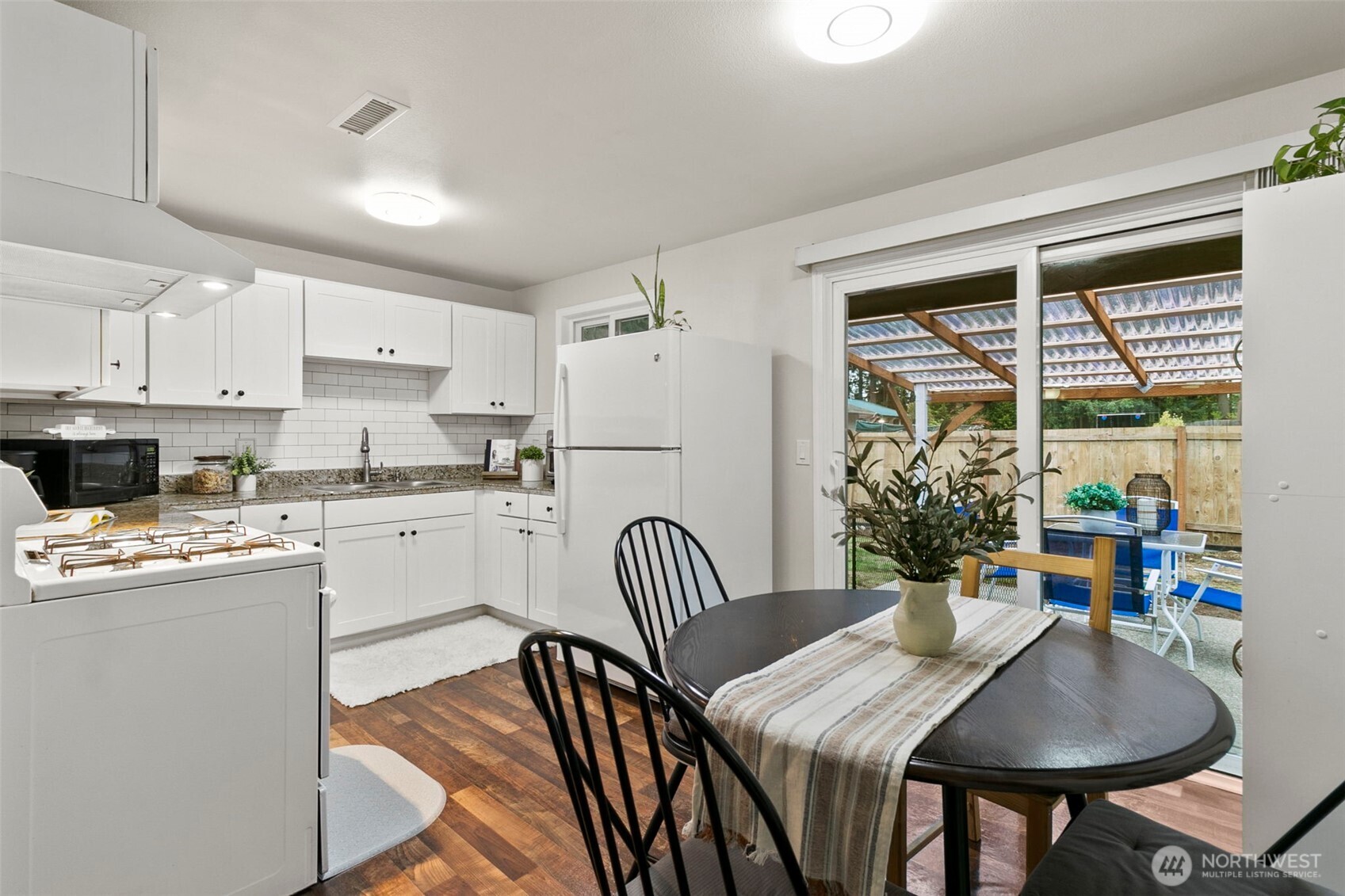 26604 191st Place Southeast Covington, WA 98042 - Photo 15 of 34 a kitchen with stainless steel appliances granite countertop a dining table chairs and a refrigerator
