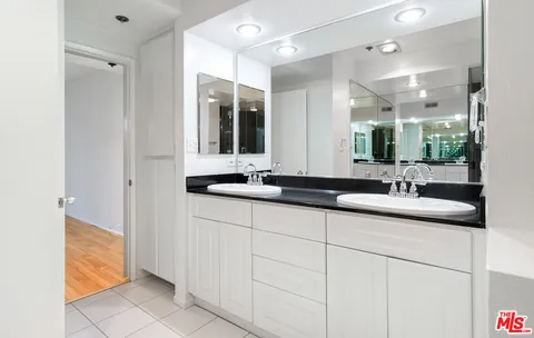 a bathroom with double sink and a mirror
