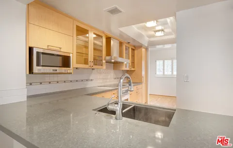 a kitchen with granite countertop a sink and a stove top oven