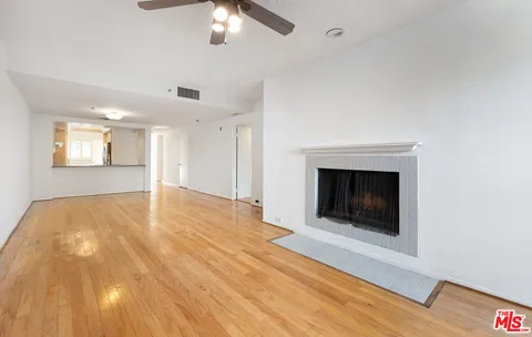 a view of empty room with wooden floor and fireplace