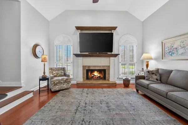 a living room with furniture a flat screen tv and a fireplace