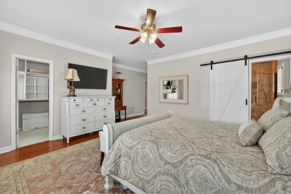 a bedroom with a bed and a flat tv screen on dresser