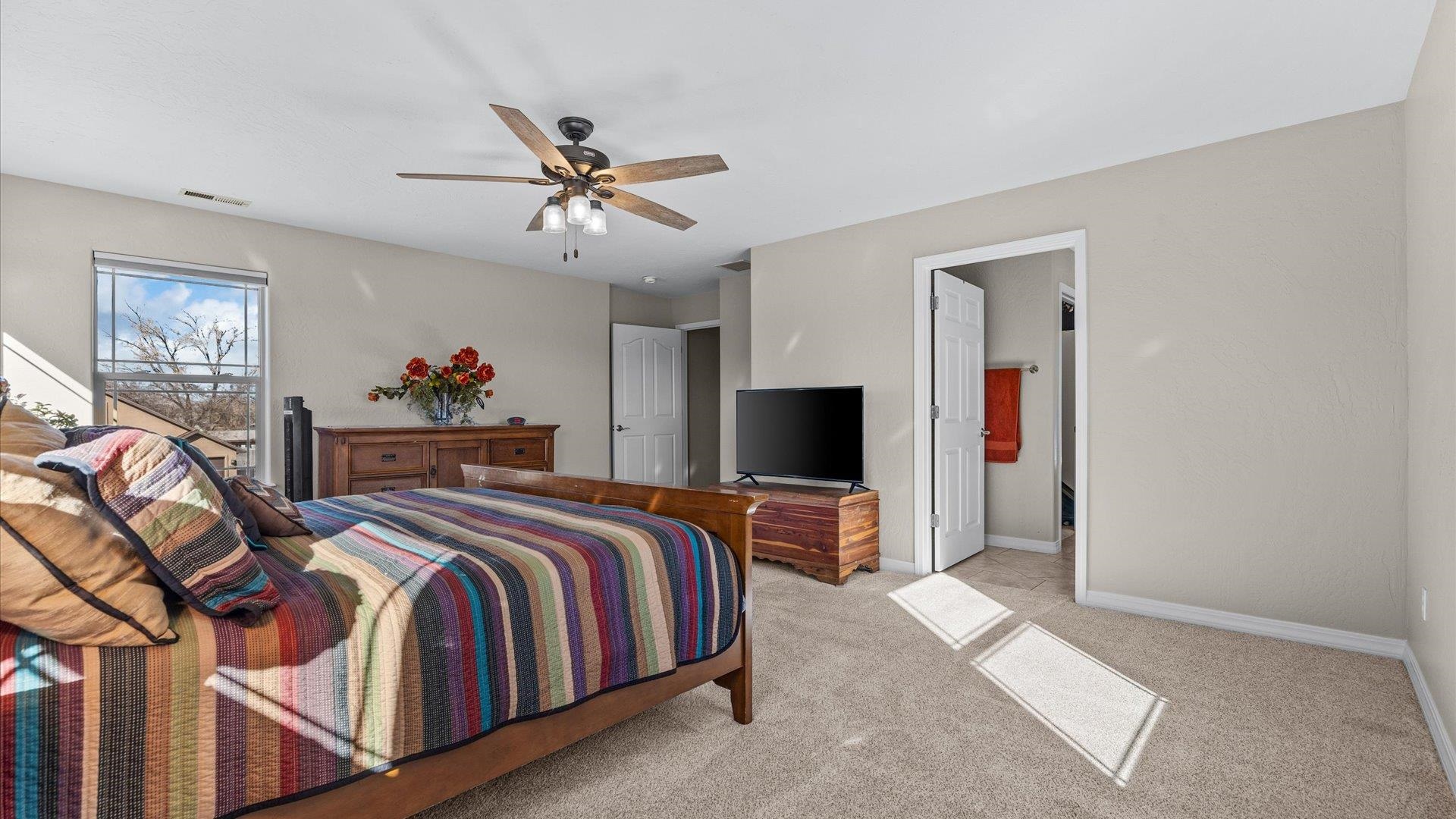 1427 Satterfield Avenue Fruita, CO 81521 - Photo 16 of 29 a bedroom with bed and a chandelier