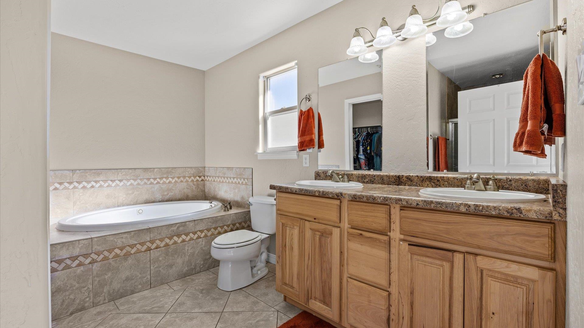 1427 Satterfield Avenue Fruita, CO 81521 - Photo 17 of 29 a bathroom with a granite countertop toilet a sink and a mirror