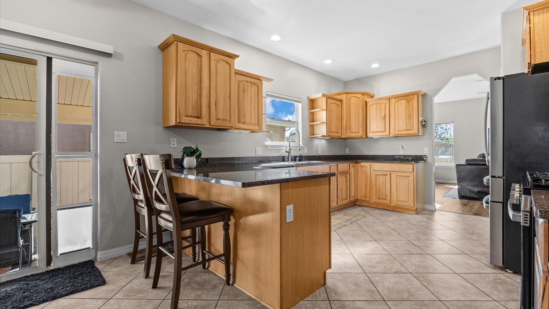 1427 Satterfield Avenue Fruita, CO 81521 - Photo 9 of 29 a kitchen with stainless steel appliances granite countertop a stove a sink a refrigerator and island