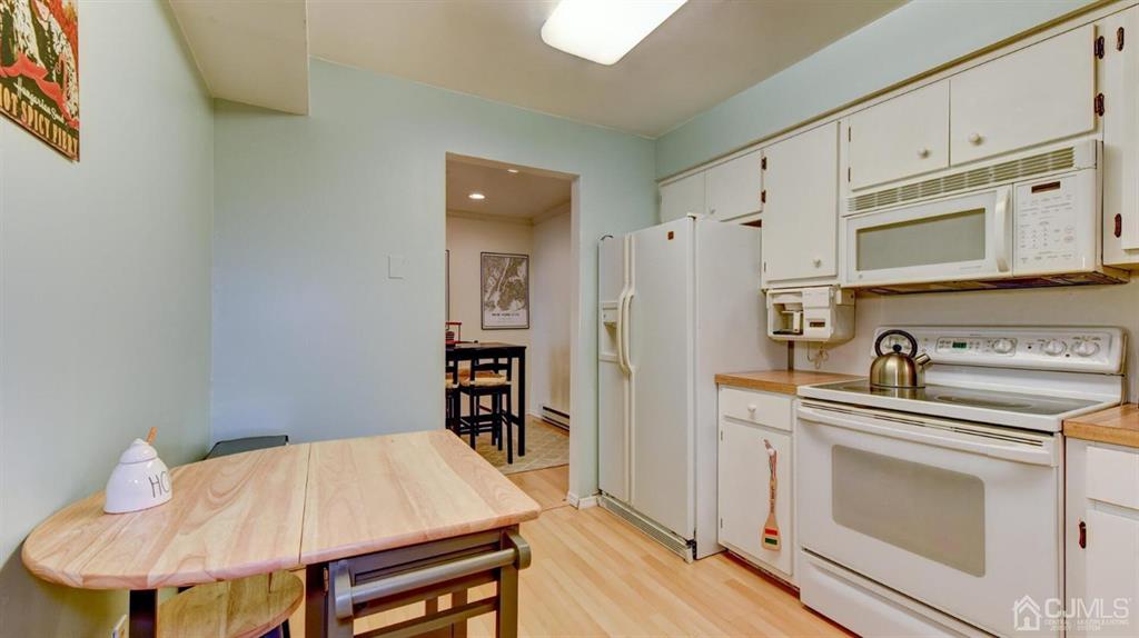 3 The Crescent Clinton, NJ 08809 - Photo 19 of 37 a kitchen with stainless steel appliances a stove a refrigerator cabinets and a dining table
