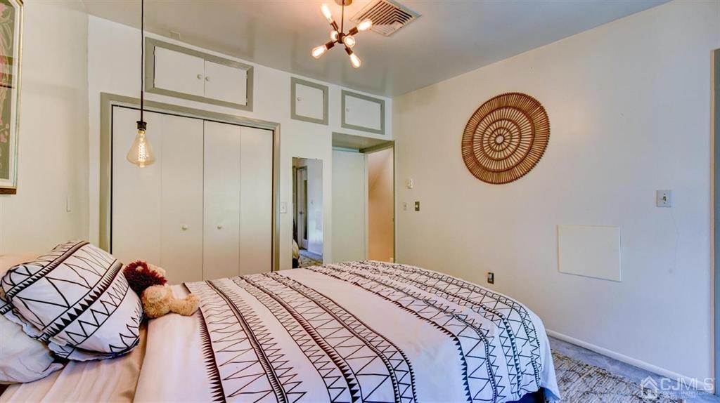 3 The Crescent Clinton, NJ 08809 - Photo 30 of 37 a bedroom with a bed and a chandelier