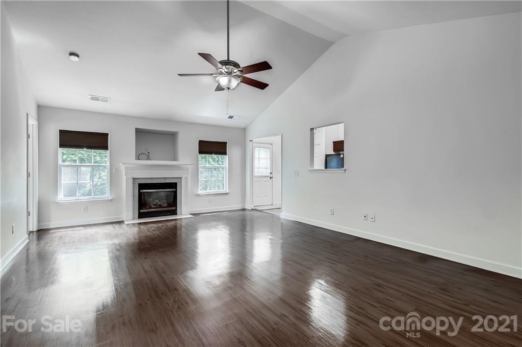 1416 Key Ridge Court Charlotte, NC 28216 - Photo 4 of 28 a view of an empty room with wooden floor fireplace and a window
