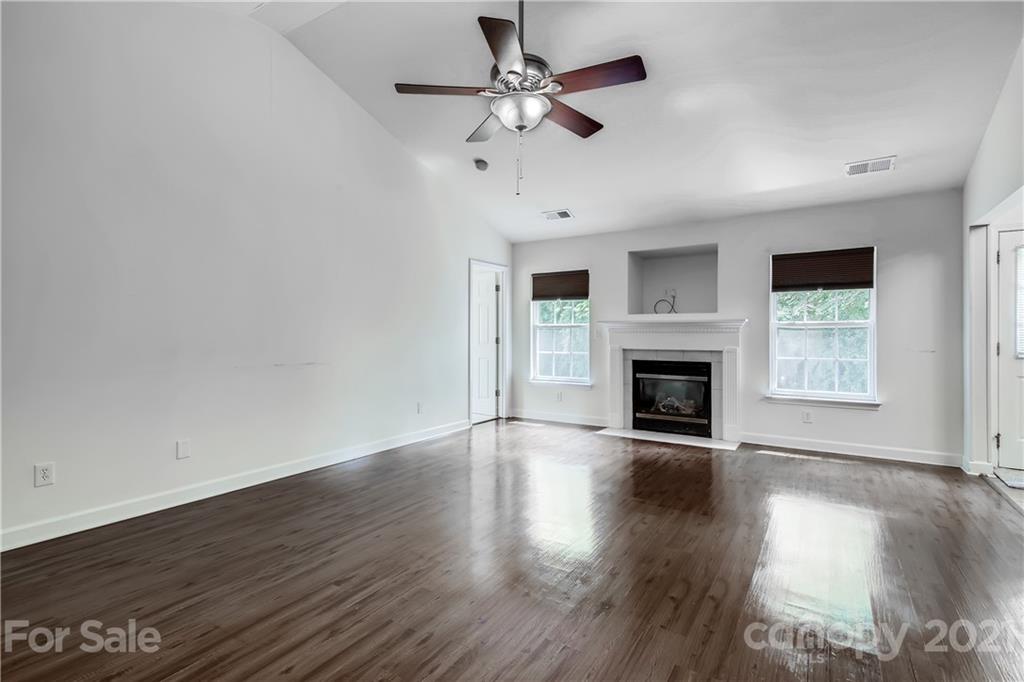 1416 Key Ridge Court Charlotte, NC 28216 - Photo 5 of 28 an empty room with wooden floor fireplace and windows