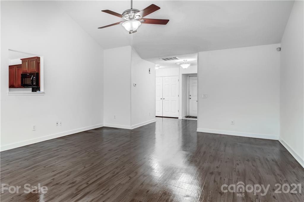 1416 Key Ridge Court Charlotte, NC 28216 - Photo 8 of 28 a view of an empty room with wooden floor and a ceiling fan