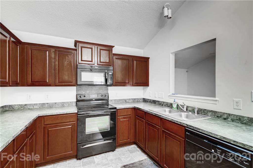 1416 Key Ridge Court Charlotte, NC 28216 - Photo 10 of 28 a kitchen with stainless steel appliances granite countertop a sink stove and cabinets