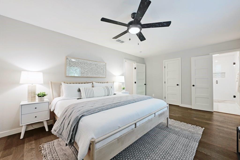6700 Kings Point Austin, TX 78723 - Photo 23 of 40 Hardwood floors and a ceiling fan create a comfortable and modern bedroom retreat.