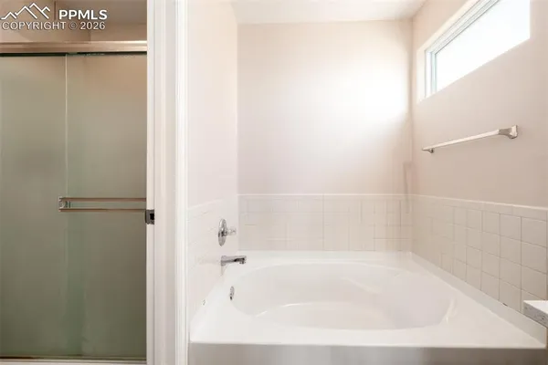 a white bath tub sitting next to a shower