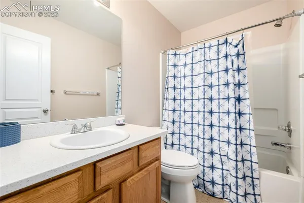 a bathroom with a sink a toilet and shower curtain