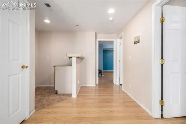 a view of a hallway with wooden floor and closet