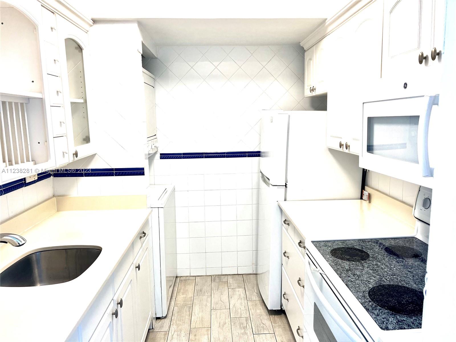 520 Brickell Key Drive, Unit A917 Miami, FL 33131 - Photo 9 of 12 a kitchen with a sink and a refrigerator