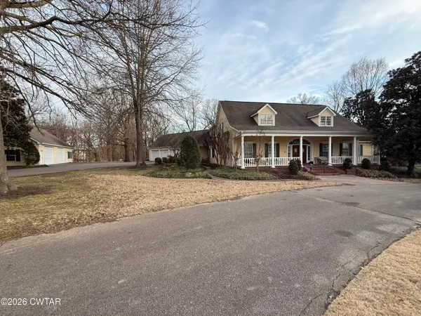 a front view of residential houses with yard and trees