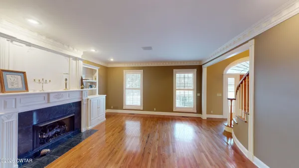 a living room with fireplace furniture and a wooden floor
