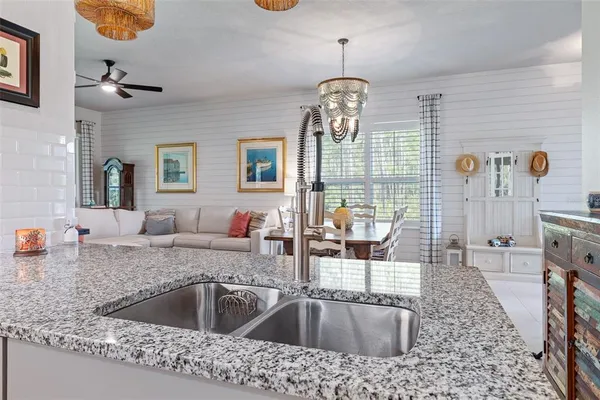 a kitchen with a sink granite counter tops and a chandelier