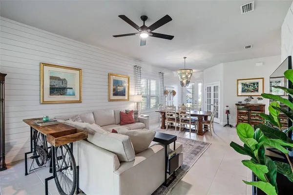 a living room with furniture kitchen view and a chandelier