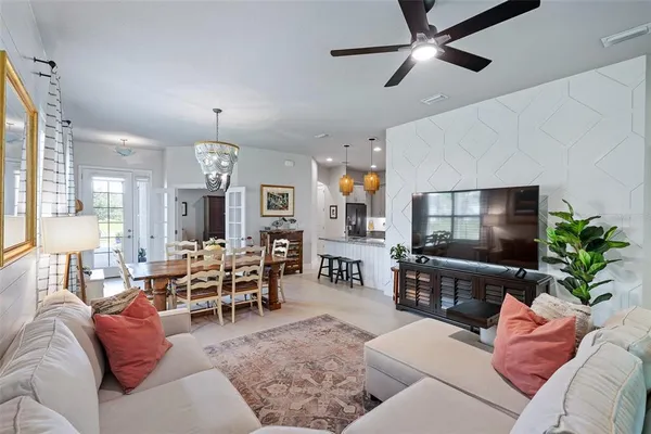 a living room with furniture kitchen view and a large window