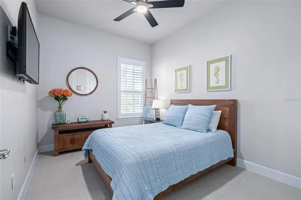 a bedroom with a bed and a flat tv screen on the dresser