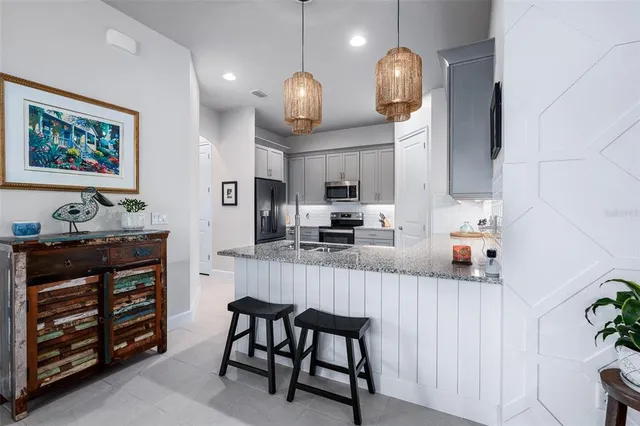 a kitchen with stainless steel appliances a dining table and chairs in it