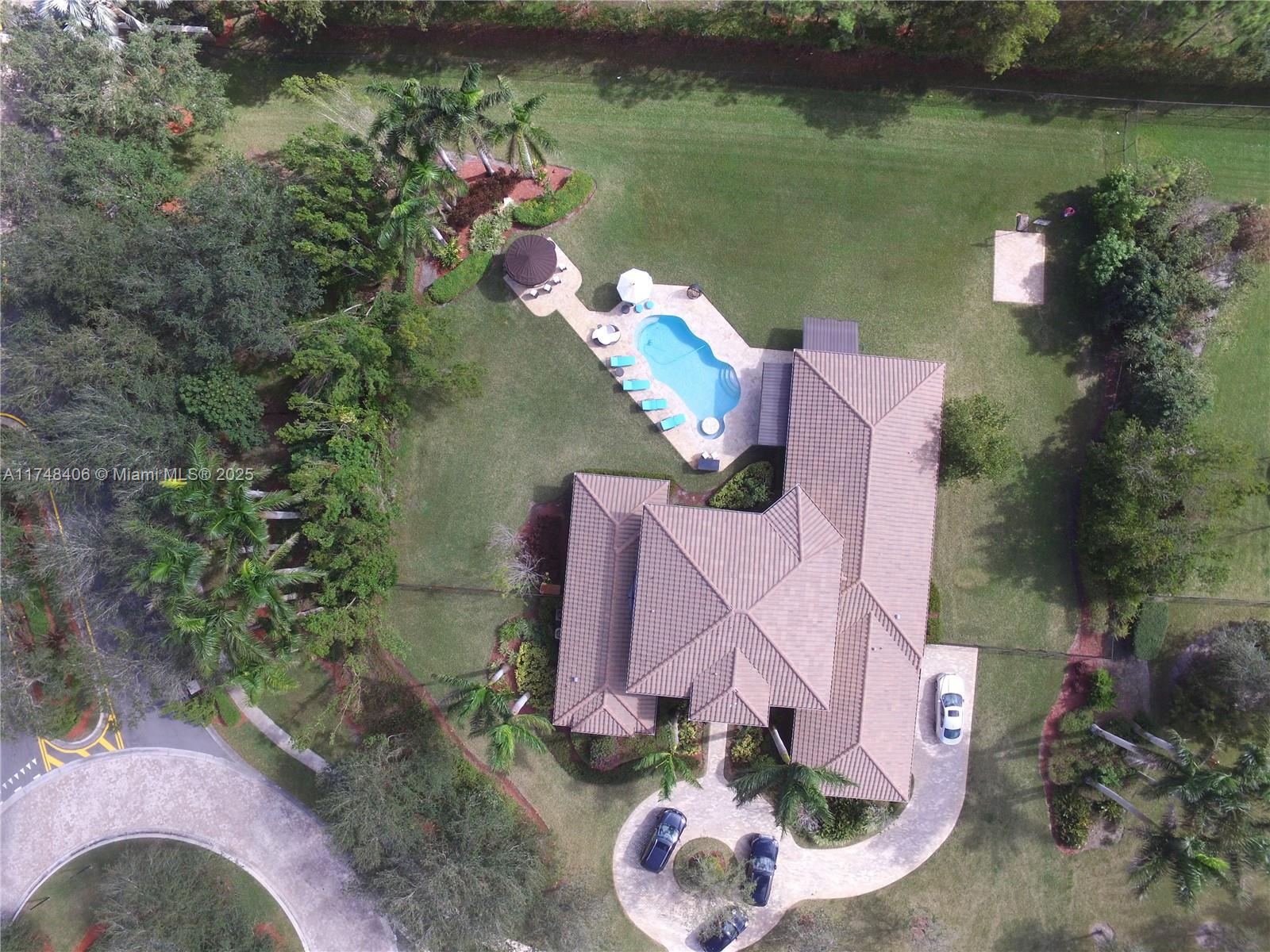 an aerial view of a house with a yard basket ball court and outdoor seating