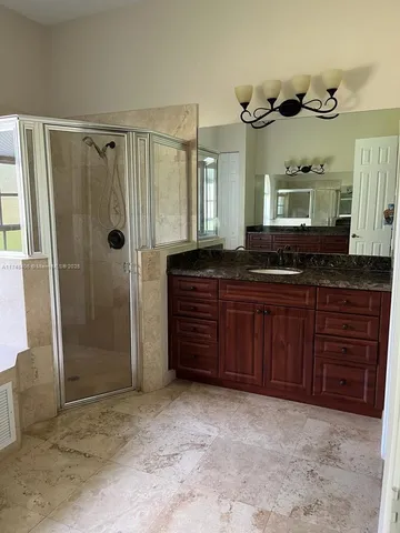 a bathroom with a granite countertop sink and a mirror