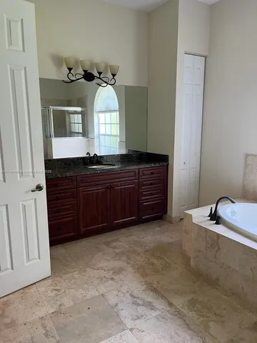 a spacious bathroom with a granite countertop sink and a mirror