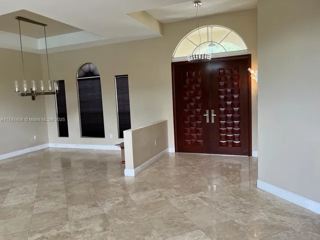 a view of a hallway with windows and chandelier