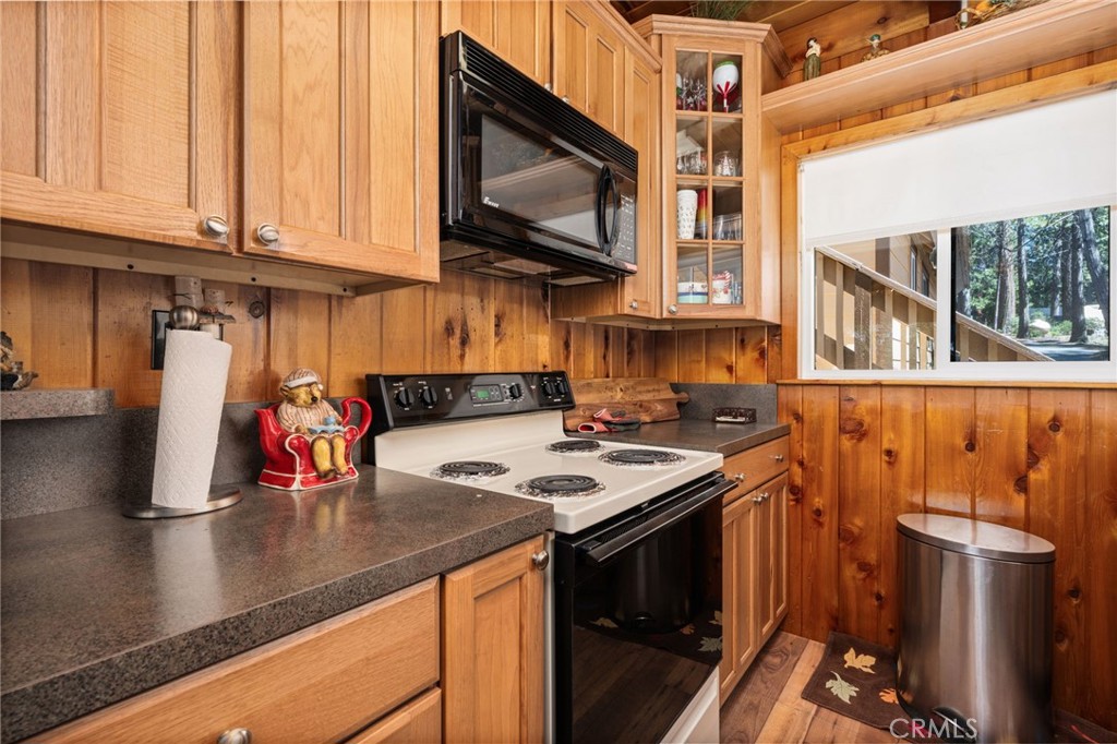 42031 North Aspen Road Shaver Lake, CA 93664 - Photo 16 of 49 a kitchen with stainless steel appliances granite countertop a sink a stove and a microwave oven with wooden floor