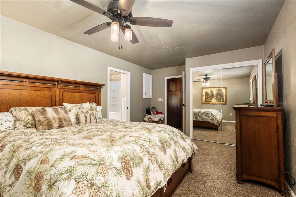 42031 North Aspen Road Shaver Lake, CA 93664 - Photo 26 of 49 a bedroom with a large bed and a chandelier