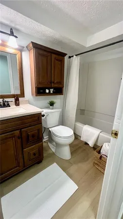 a bathroom with a sink a toilet a mirror and shower