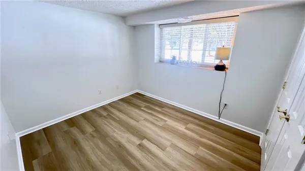 a view of a room with wooden floor and windows