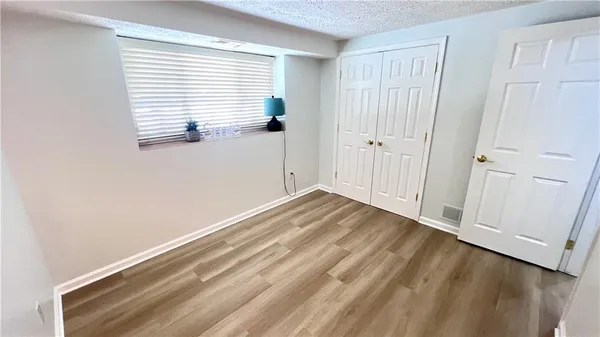 a view of empty room with wooden floor and entryway