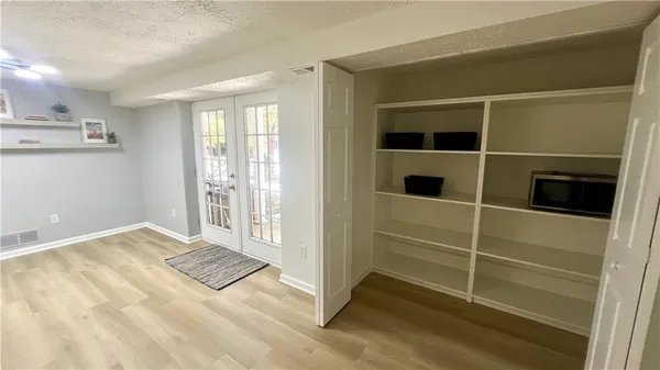a view of walk in closet with empty racks