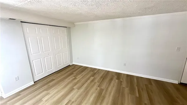 a view of an empty room with wooden floor