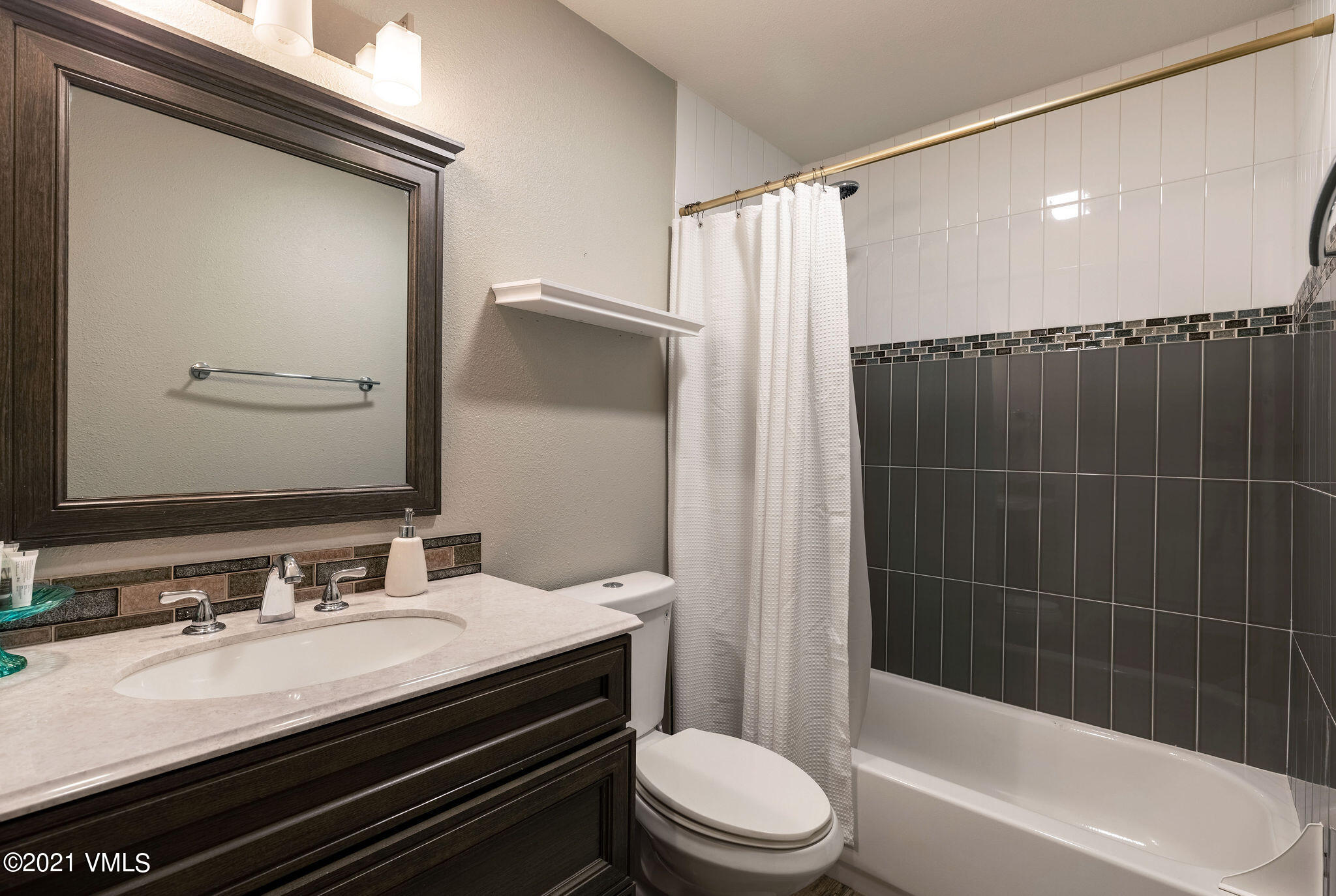 212 Eagle Road, Unit 3D Avon, CO 81620 - Photo 4 of 8 a bathroom with a sink a toilet a mirror and shower