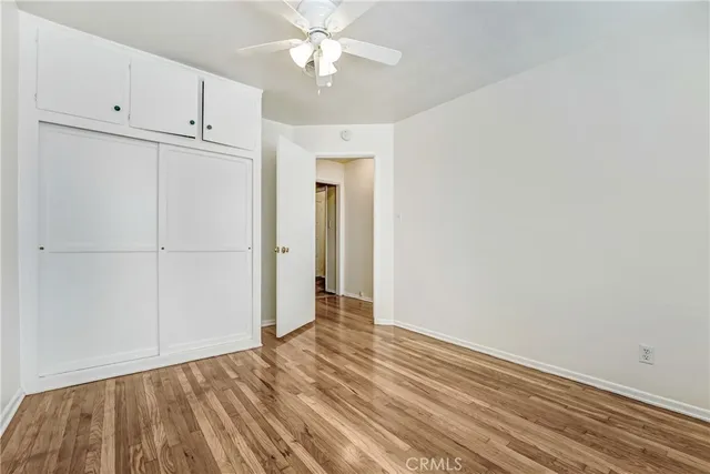 a view of an empty room with closet and a window