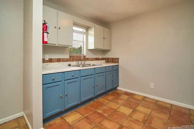 a kitchen with granite countertop wooden cabinets and a stove top oven