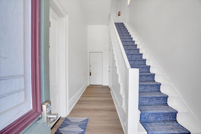 a view of a hallway with wooden floor and entryway