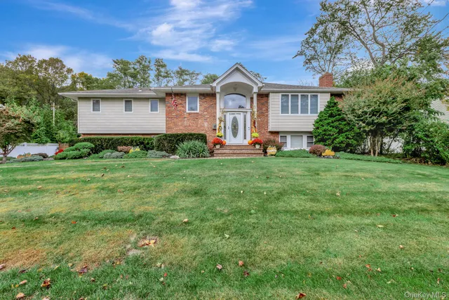 a view of a house with a big yard and large trees