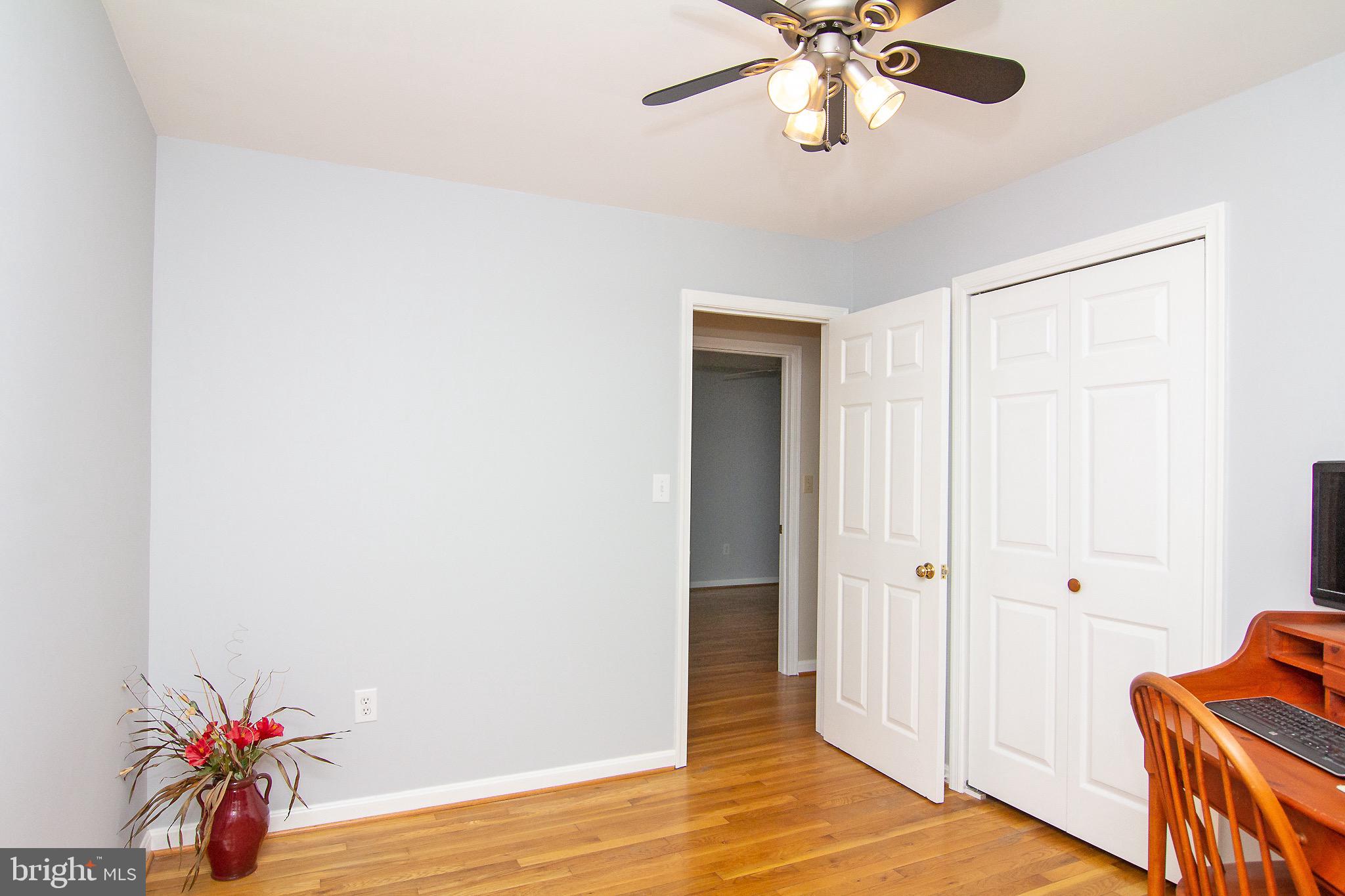 4813 Millers Station Road Hampstead, MD 21074 - Photo 21 of 32 a view of an empty room with wooden floor and a ceiling fan