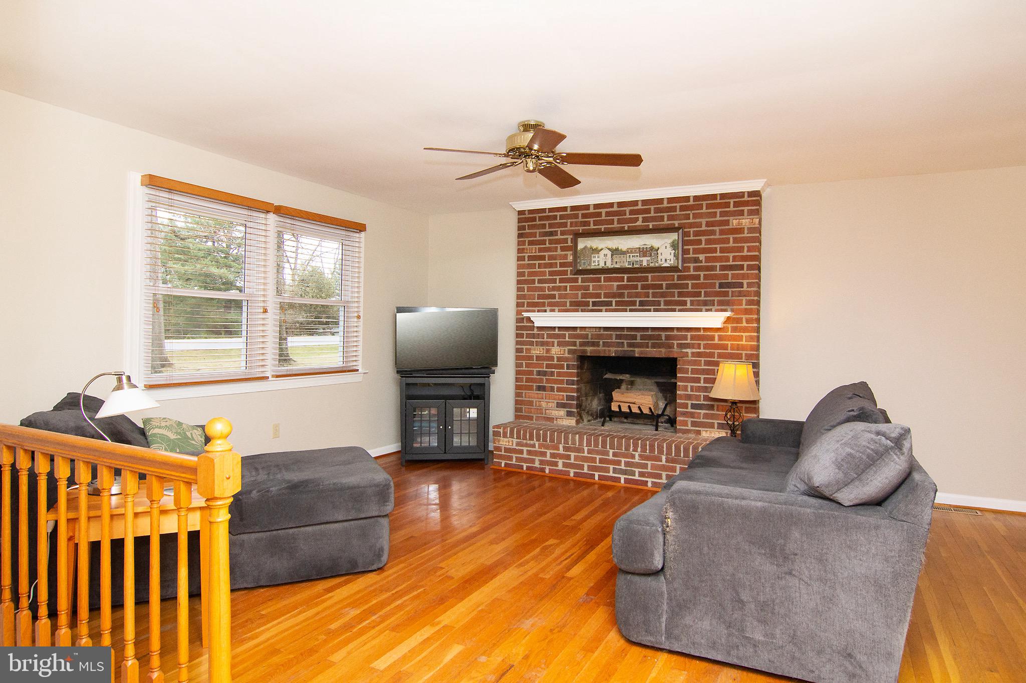 4813 Millers Station Road Hampstead, MD 21074 - Photo 5 of 32 a living room with furniture a fireplace and a flat screen tv