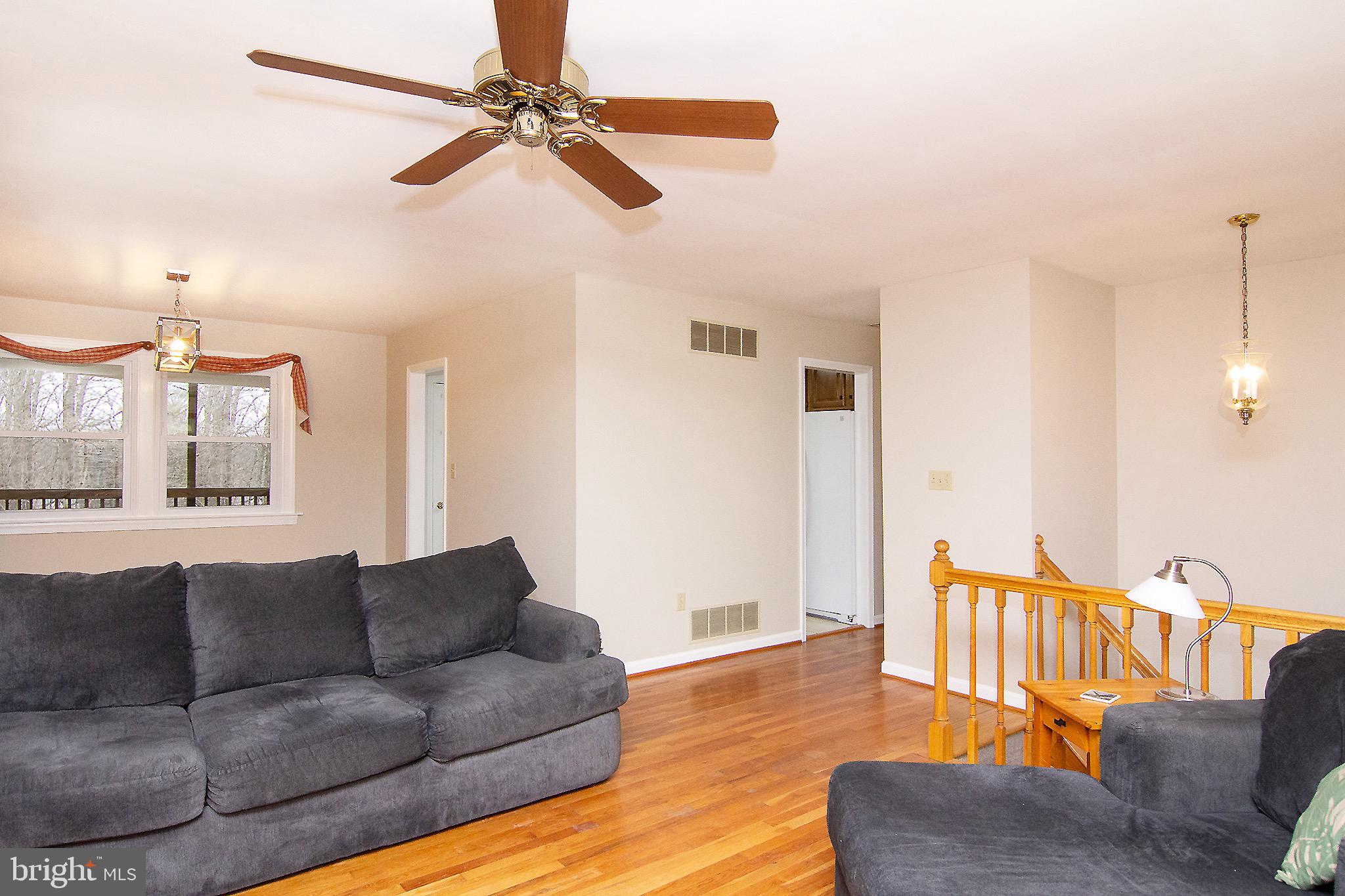 4813 Millers Station Road Hampstead, MD 21074 - Photo 6 of 32 a living room with furniture ceiling fan and a wooden floor
